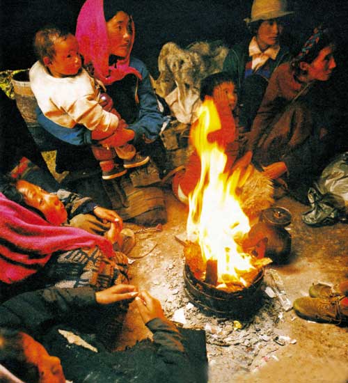 Listening to a story while sitting aside a yak dung fire. Photo by Jogod.