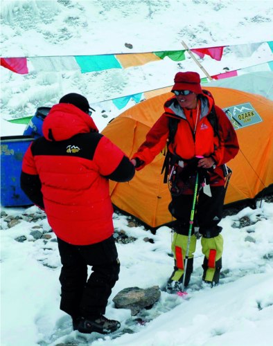 On june 29,the sudden change of weather enabled the mountaineers to return from mountaineering.Samdrup, the team leader,is greeting Jiji in retreat.