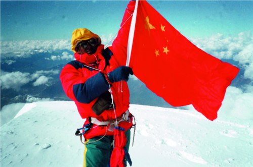 At nine past 12 o??clock on October 30th, 1992, the China Joint Friendship mountaineering expedition successfully reached Mt.Namjabarwa.  Penpa Tashi is raising the national flag. Photo by Gyapo