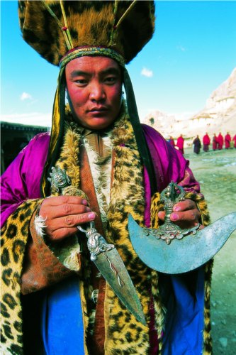 Khenpo Gasong Tenzin is holding religious instruments.