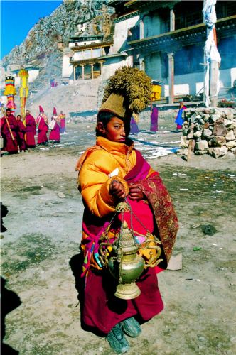 A young monk handing religious instruments.